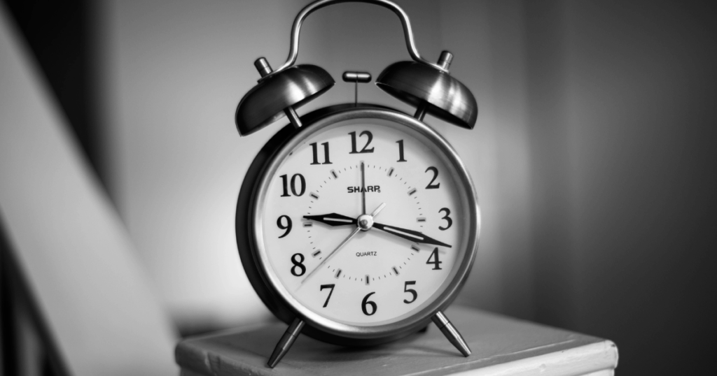 chrome alarm clock setting on white book