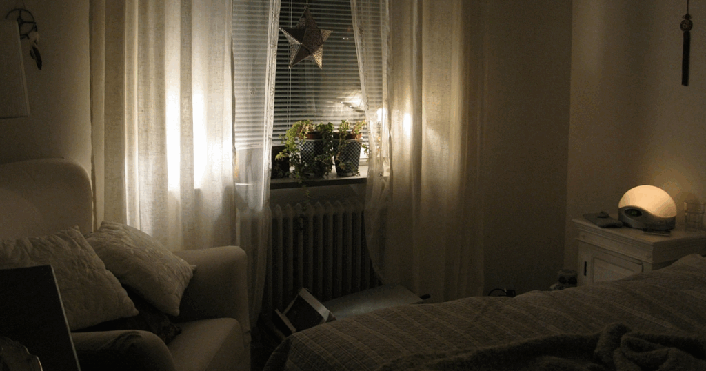 Peaceful bedroom scene with low lighting